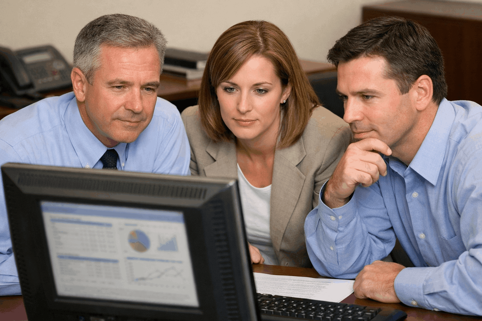 Team reviewing plan data on a computer screen